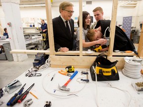 (left to right) Education Minister David Eggen, watches as Westmount Junior High School Grade 9 students Jacob Shewchuk, 14, David Coleman, 14, Kyle Mezei, 15, work on an electrical project in their Trades class, in Edmonton Thursday April 13, 2017. Education Minister David Eggen announced results of a curriculum survey the education ministry conducted, during a press conference in the classroom Thursday. Photo by David Bloom