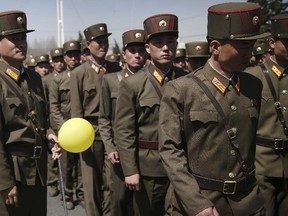 North Korean soldiers walk in the Ryomyong residential area after attending its official opening ceremony on Thursday, April 13, 2017, in Pyongyang, North Korea. (AP Photo/Wong Maye-E)