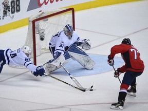 Toronto Maple Leafs goalie Frederik Andersen (31) makes a save in front of defenseman Morgan Rielly (44) and Washington Capitals right wing T.J. Oshie (77) during the third period in Game 1 of an NHL Stanley Cup first round playoff series in Washington, Thursday, April 13, 2017. (AP Photo/Molly Riley) ORG XMIT: VZN213