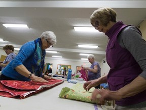 Louise Barr and Colleen Kennedy fold fabric for a group called Grandmothers for Africa which has an upcoming fabric sale on April 22. (Greg Southam)