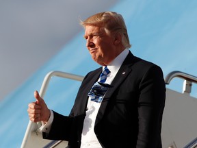 President Donald Trump gives a thumbs-up as he walks down the steps off Air Force One as he arrives at the Palm Beach International Airport, Thursday, April 13, 2017, in West Palm Beach, Fla. (AP Photo/Alex Brandon)