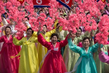 Women wearing traditional Korean dress wave flowers and shout slogans as they pass North Korea's leader Kim Jong Un during a mass rally marking the 105th anniversary of the birth of late North Korean leader Kim Il Sung in Pyongyang on April 15, 2017. (ED JONES/AFP/Getty Images)