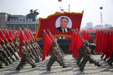North Korean soldiers carry flags and a photo of late leader Kim Il Sung as they march across Kim Il Sung Square during a military parade on Saturday, April 15, 2017, in Pyongyang, North Korea to celebrate the 105th birth anniversary of Kim Il Sung, the country's late founder and grandfather of current ruler Kim Jong Un. (AP Photo/Wong Maye-E)