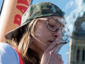 A woman smokes a joint during the annual 420 marijuana rally on Parliament hill on Wednesday, April 20, 2016 in Ottawa. THE CANADIAN PRESS/Justin Tang