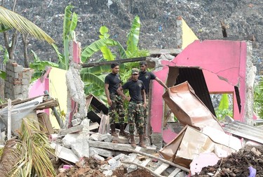 Sri Lankan military personnel stand among damaged homes at the site of a collapsed garbage dump in Colombo on April 15, 2017. (LAKRUWAN WANNIARACHCHI/AFP/Getty Images)