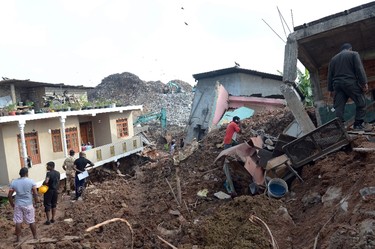 Sri Lankan residents walk through damaged homes at the site of a collapsed garbage dump in Colombo on April 15, 2017. (LAKRUWAN WANNIARACHCHI/AFP/Getty Images)