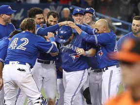 Kendrys Morales of the Toronto Blue Jays is congratulated at home plate by teammates after hitting a game-winning solo home run during MLB action against the Baltimore Orioles at Rogers Centre on April 15, 2017. (Tom Szczerbowski/Getty Images)