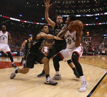 Toronto Raptors DeMar DeRozan G (10) is double teamed by Milwaukee Bucks Spencer Hawes F (00) and Malcolm Brogdon G (13) during the first half of Game 1 in Toronto, Ont. on Saturday April 15, 2017. Jack Boland/Toronto Sun/Postmedia Network