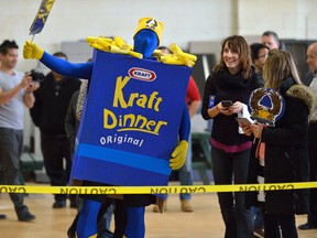 Employees of Automata Solutions cheer on as a 2500 boxes of Kraft dinner fall in a domino arrangement on Thursday April 13, 2017. The company collected 8,000 boxes to donate to the London Food Bank spring food drive. (MORRIS LAMONT, The London Free Press)