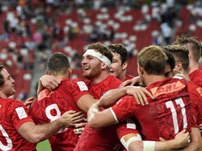 Isaac Kaay (centre) of Canada celebrates with teammates after victory against the U.S. in the cup final of the Singapore Rugby Sevens tournament in Singapore on Sunday, April 16, 2017. (Roslan Rahman/Getty Images)
