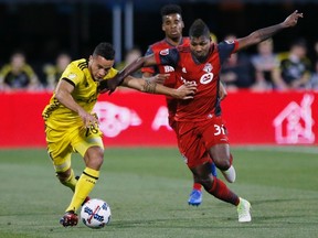 Columbus Crew midfielder Niko Hansen battles against Toronto FC midfielder Armando Cooper during Saturday’s game. (AP)