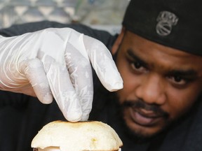 In this March 1, 2017, photo, chef Miguel Navarro inspects a Le Bleu hamburger, made with caramelized onions and blue cheese on top of portobello mushroom and lettuce, at the Atlas Meat-Free Delicatessen in Miami. When Ryan Bauhaus first started experimenting with faux meats, he fixated on recreating that subtle blood taste, settling on a tomato paste blend to mimic the acidic, iron flavor. The fatty part of meat was also not to be forgotten. Bauhaus boiled down mushrooms until he got the desired gelatinous, rubbery fat found on the back of a roast. (AP Photo/Alan Diaz)