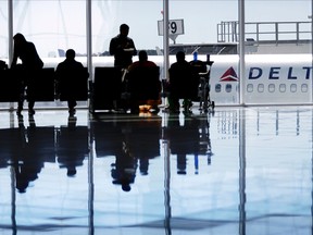 In this Thursday, Oct. 13, 2016, file photo, a Delta Air Lines jet sits at a gate at Hartsfield-Jackson Atlanta International Airport, in Atlanta. Delta is giving airport employees permission to offer passengers up to almost $10,000 in compensation to give up their seats on overbooked flights. Delta's move comes as United Airlines struggles to recover from images of a passenger's forced removal from a sold-out flight. (AP Photo/David Goldman, File)