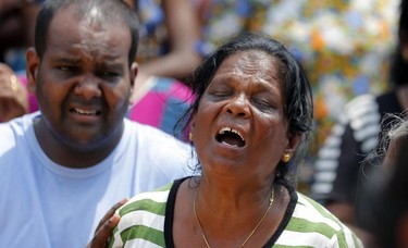 A Sri Lankan woman affected by the garbage dump collapse cries as she awaits details about her missing family members outside an information center in Meetotamulla, on the outskirts of Colombo, Sri Lanka, Sunday, April 16, 2017. The death toll from the collapse of the massive garbage mound near Sri Lanka's capital rose to more than a dozen Sunday, and residents feared more victims could be buried underneath the debris. Maj. Gen. Sudantha Ranasinghe, who is heading the rescue efforts, said 78 houses were destroyed and more than 150 were damaged. (AP Photo/Eranga Jayawardena)