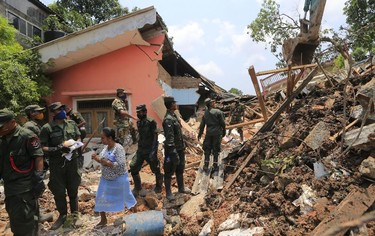 Sri Lankan army rescuers remove debris from a buried house following a garbage mound collapse in  Meetotamulla, on the outskirts of Colombo, Sri Lanka, Colombo, Sri Lanka, Monday, April 17, 2017. Rescuers on Monday were digging through heaps of mud and trash that collapsed onto a clutch of homes near a garbage dump outside Sri Lanka's capital, killing dozens and possibly burying dozens more. (AP Photo/Eranga Jayawardena)