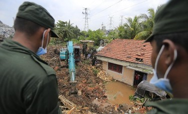 Sri Lankan military officers work in a rescue mission at the site of a garbage dump collapse in Meetotamulla, on the outskirts of Colombo, Sri Lanka, Sunday, April 16, 2017. The death toll from the collapse of the massive garbage mound near Sri Lanka's capital rose to more than a dozen Sunday, and residents feared more victims could be buried underneath the debris. Maj. Gen. Sudantha Ranasinghe, who is heading the rescue efforts, said 78 houses were destroyed and more than 150 were damaged. (AP Photo/Eranga Jayawardena)
