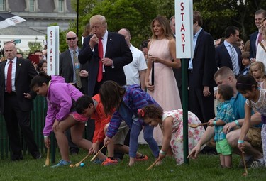 President Donald Trump, accompanied by first lady Melania Trump, blows a whistle to begin an Easter Egg Roll race on the South Lawn of the White House in Washington, Monday, April 17, 2017, during the annual White House Eastern Egg Roll. (AP Photo/Susan Walsh)