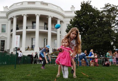 Eggs fly as Caroline Earnshaw, 10, helps her sister Brooke Earnshaw, 2, during the White House Easter Egg Roll on the South Lawn of the White House in Washington, Monday, April, 17, 2017. President Donald Trump and first lady Melania Trump are set to host the official annual Easter egg roll at the White House. (AP Photo/Carolyn Kaster)