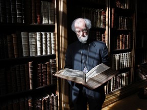 In this file photo dated Wednesday, May 25, 2011, then Archbishop of Canterbury Dr Rowan Williams poses with a 400-year old King James Bible at his London residence, Lambeth Palace. According to a statement from the London Museum released Sunday April 16, 2017, the remains of five former archbishops of Canterbury were discovered during renovation works inside a secret tomb beneath a building located next to Lambeth Palace, including the remains of Richard Bancroft who became archbishop in 1604 and played a major role in production of the King James Bible. (AP Photo/Akira Suemori, FILE)