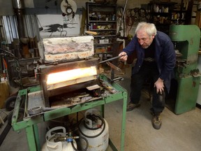 Artist Jerry Vrabec works in his London studio. Vrabec is a master gold and silversmith who sculpts in metals. Two of his pieces are shown at left. He is one of 43 London artists opening his work space to the public this weekend. (MORRIS LAMONT, The London Free Press)