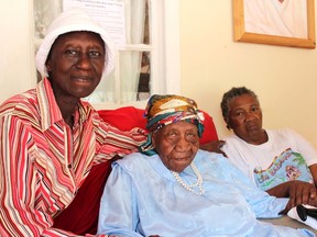 The world's oldest person Violet Brown, centre, poses with her care givers Elaine Mcgrowder , left, and Dolet Grant at her home in Duanvale district of Trelawny, Jamaica, Sunday, April 16, 2017. The 117-year-old woman living in the hills of western Jamaica is believed to have become the world's oldest person, according to groups that monitor human longevity. (AP Photo/Raymond Simpson)