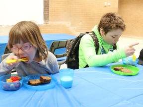 BRUCE BELL/THE INTELLIGENCER
Grade 2 student Collette Davis (left) and her brother, Dante (Grade 5), enjoy a bite to eat during Breakfast Celebration at Harry J. Clarke Public School on Tuesday morning. After a decade-long absence, the Food for Learning program returned to the east-end school in the fall.
