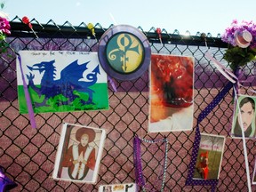 In this April 6, 2017, photo, fan artwork of Prince hangs on a new memorial fence in the parking lot of Paisley Park Museum, the former home and recording complex of the late superstar in Chanhassen, Minn. Affidavits and search warrants were unsealed in Carver County District Court Monday, April 17, 2017, as the yearlong investigation into Prince's death continues. (AP Photo/Jeff Baenen)