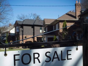 A for sale sign is shown in front of west-end Toronto homes on April 9, 2017. The Canadian Real Estate Association says home sales last month hit a record high. (Graeme Roy/The Canadian Press)
