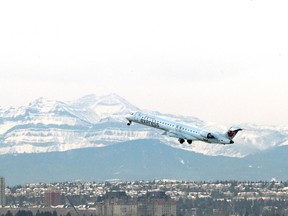 An Air Canada plane departs the Calgary International Airport with the Rocky Mountains in the background on Dec. 29, 2016. (Jim Wells/Postmedia Network)