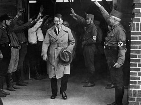 In this Dec. 5, 1931 file photo, Adolf Hitler, leader of the National Socialists, is saluted as he leaves the party's Munich headquarters. The book, "Human Rights After Hitler" by British academic Dan Plesch, says Hitler was put on the United Nations War Crimes Commission's first list of war criminals in December 1944, but only after extensive debate and formal charges brought by Czechoslovakia. Plesch, who led the campaign for open access to the commission's archive, told The Associated Press on Tuesday, April 18, 2017, that the documents show "the allies were prepared to indict Hitler as head of state, and this overturns a large part of what we thought we knew about him." (AP Photo, File)