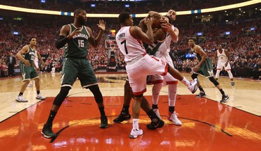 Toronto Raptors Kyle Lowry G (7) and Jonas Valiciunas (17) fight for control of the ball with Milwaukee Bucks Khris Middleton G (22) during the first quarter of Game 2 in Toronto, Ont. on Tuesday April 18, 2017. Jack Boland/Toronto Sun/Postmedia Network