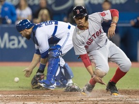 Boston Red Sox’s Mookie Betts slides in safe to home plate while Jays catcher Russell Martin picks up the ball April 18, 2017. (THE CANADIAN PRESS)