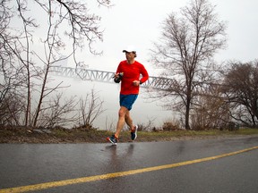 A runner passes the Prince of Wales Bridge along the Ottawa River as the river was blanketed with fog Sunday April 16, 2017.