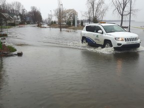 A municipal vehicle drives through floodwaters on low-lying Jacques-Cartier Street in Gatineau Wednesday.