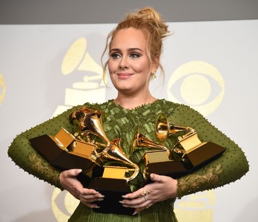 Adele poses in the press room with her trophies, including the top two Grammys of Album and Record of the Year for her blockbuster hit "Hello" and the album "25", during the 59th Annual Grammy music Awards on February 12, 2017, in Los Angeles, California.  / AFP / Robyn BECK        (Photo credit should read ROBYN BECK/AFP/Getty Images)