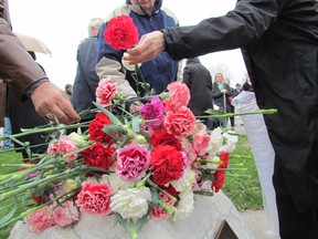 In this file photo, carnations are placed on a stone at the Missing Worker Memorial in Sarnia's Centennial Park Sunday during a Day of Mourning ceremony. This year's ceremony is set for April 28, 6 p.m., at the Firefighter Memorial Garden next to the Clifford Hansen Fire Station on East Street.  (File photo/THE OBSERVER)