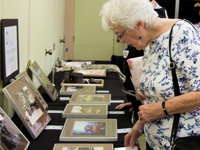 Margaret Turner looks at photographs taken from the Queen’s University archives at her first pop-up museum, “Bring your Thing” event on Tuesday. “I immigrated to Canada 50 years ago from Ireland, I love to learn about the country’s history,” Turner said. (Taylor Bertelink/For The Whig-Standard)