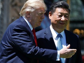 In this April 7, 2017, file photo, U.S. President Donald Trump gestures as he and Chinese President Xi Jinping walk together after their meetings at Mar-a-Lago in Palm Beach, Fla. (AP Photo/Alex Brandon, File)