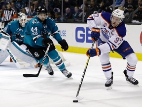 Edmonton Oilers' Connor McDavid (97) reaches for the puck next to San Jose Sharks' Marc-Edouard Vlasic (44) during the second period in Game 4 of a first-round NHL hockey playoff series Tuesday, April 18, 2017, in San Jose, Calif.
