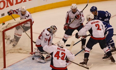 the puck just squirts through Washington Capitals Braden Holtby G (70) pads but Tom Wilson RW (43) saves it near the redline during the first period of Game 4 in Toronto on Wednesday April 19, 2017. Jack Boland/Toronto Sun/Postmedia Network