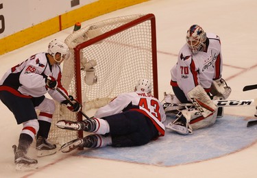 the puck just squirts through Washington Capitals Braden Holtby G (70) pads but Tom Wilson RW (43) saves it near the redline during the first period of Game 4 in Toronto on Wednesday April 19, 2017. Jack Boland/Toronto Sun/Postmedia Network