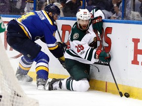 Minnesota Wild's Jason Pominville, right, reaches for the puck as St. Louis Blues' Carl Gunnarsson, of Sweden, watches during the third period in Game 4 of an NHL hockey first-round playoff series Wednesday, April 19, 2017, in St. Louis. The Wild won 2-0. (AP Photo/Jeff Roberson)