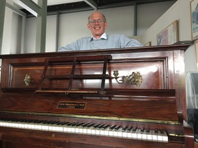 Piano tuner Martin Backhouse with the piano where he found a stash of gold, smiles in Ludlow Museum in Ludlow, England, April 20, 2017. As a mystery surrounds the identity of the rightful heirs to a treasure trove of gold coins. British officials say they have been unable to trace the rightful heirs to a trove of gold coins worth a "life-changing" amount of money. The school that owns the piano and the tuner who found the gold are now in line for a windfall after a coroner investigating the find declared it treasure. (Richard Vernalls/PA via AP)