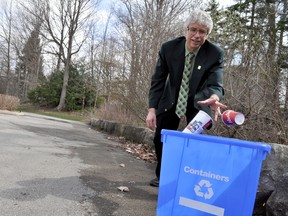 Jay Stanford, the City of London’s director of environment, fleet, and solid waste, tosses recyclables into a blue box. CHRIS MONTANINI\LONDONER\POSTMEDIA NETWORK
