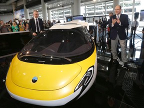 Prince Albert II of Monaco, right, and Juraj Vaculik, CEO and co-founder of AeroMobil, applaud after unveiling the latest prototype of a flying car, in Monaco, Thursday, April 20, 2017. The light frame plane whose wings can fold back, like an insect is boosted by a rear propeller. The company says it is planning to accept first preorders for the vehicle as soon as later this year. (AP Photo/Claude Paris)