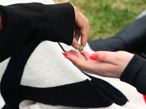 A marijuana bud is passed during the annual 4/20 gathering at the Manitoba legislature grounds on Thurs., April 20, 2017. Kevin King/Winnipeg Sun/Postmedia Network