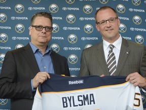 In this May 28, 2015, file photo, Buffalo Sabres GM Tim Murray, left, and newly hired coach Dan Bylsma hold a Sabres' jersey as they pose for a photo after a news conference in Buffalo, N.Y. (AP Photo/Gary Wiepert, File)