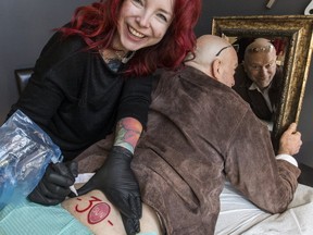 Toronto Sun columnist Mike Strobel gets a tune up on his Sun Logo tattoo from ink artist Kelly Mason. (CRAIG ROBERTSON, Toronto Sun)