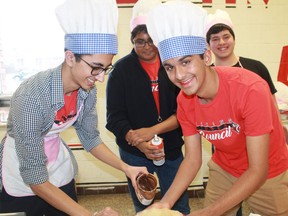 Northern Collegiate student council members Anthony Joshi, Mann Shah, Mihir Jakhi and Kevin Escoboza daubed a generous portion of Nutella onto a crepe during the school's annual MAC Night event. Carl Hnatyshyn/Postmedia Network