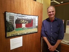 Mike Baker, curator of the Elgin County Museum stands in front of the rug created by the “Memories in Wool” rug hooking group that is run out of the Elgin County Museum. It is part of an exhibit called The Barn Raising Project that will be at the museum until May 19. (Laura Broadley/Times-Journal)